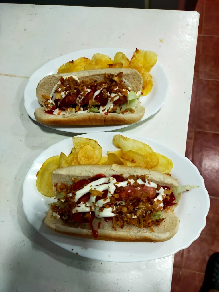 Perrito caliente delicioso adornado con patatas fritas